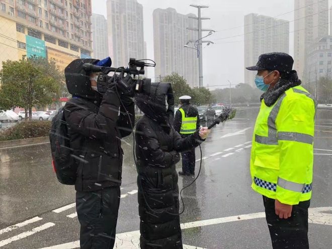 孝感市融媒體中心楊亞玲（風(fēng)雪中，采訪疫情期間重返一線的退休警察）_副本.jpg.jpg